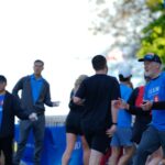 People gathered at an outdoor event with blue banners