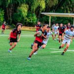 Rugby players competing vigorously on a vibrant green field, showcasing teamwork and athleticism.