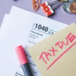 Close-up of IRS Form 1040 with 'Tax Due' note and stationery on a desk.