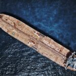 Drone shot of large tanker ship with helipads in ocean waters.