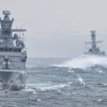 Navy warships navigating turbulent ocean waters showcasing maritime strength.