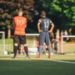 Soccer players in team jerseys standing on the field ready for the game.