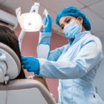 a woman getting her teeth brushed by a dentist