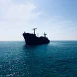 black ship on sea under white sky during daytime