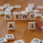 Wooden Scrabble tiles spelling 'AI' and 'NEWS' for a tech concept image.