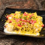 A black plate topped with food on top of a table