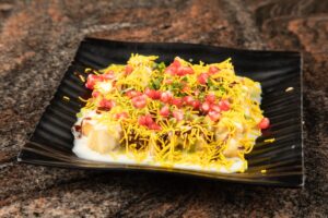 A black plate topped with food on top of a table