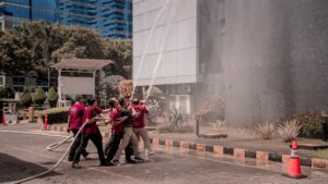Firefighters training with water hose on building