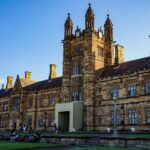Historic stone university building with towers and blue sky