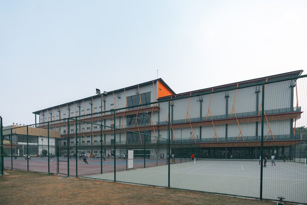 Modern sports complex with outdoor courts and building.