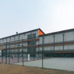 Modern sports complex with outdoor courts and building.