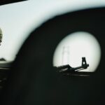 A soldier's profile with a firearm silhouetted against a blurred background, creating a tense atmosphere.