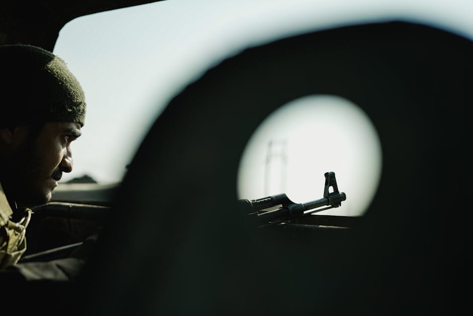 A soldier's profile with a firearm silhouetted against a blurred background, creating a tense atmosphere.
