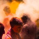 People covered in colored powder celebrating a festival celebration