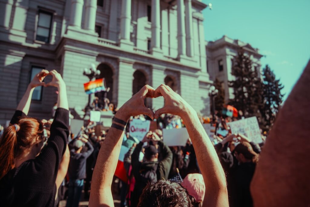 Protesters make hearts with their hands in support.