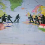 Toy soldiers face off on world map with flags.