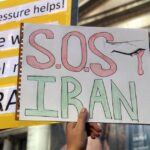 Protest sign reading SOS Iran during a demonstration in Vancouver, raising awareness for Iranian issues.