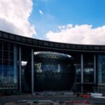 A large round building with a sky background
