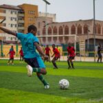 Soccer players are playing a match on a field.