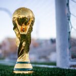 international football trophy sitting on soccer field near the goals