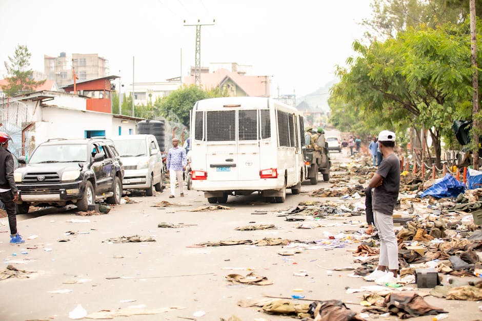 A street cluttered with debris, cars, people, and a truck, reflecting urban chaos.