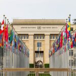 View of the United Nations Office in Geneva adorned with flags of various countries.
