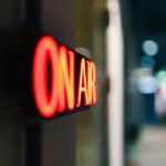 Close-up of an illuminated 'On Air' sign symbolizing live broadcasting in a studio.